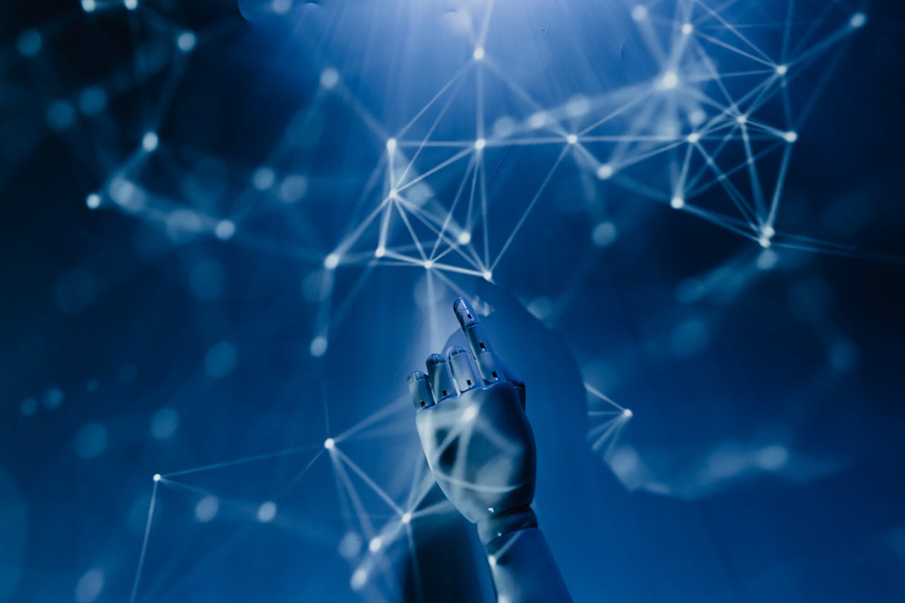 About A robotic hand reaching into a digital network on a blue background, symbolizing AI technology.