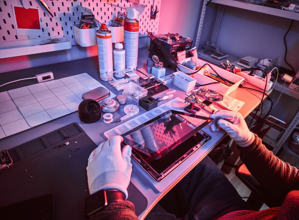 the technician repairs a broken tablet computer in a repair shop the technician repairs a broken tablet computer in a repair shop
